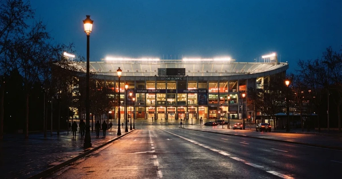 Ein großes Fußballstadion mit hell erleuchtetem Rund, aus der Ferne am Abend gesehen, davor eine breite Allee mit Laternen.
